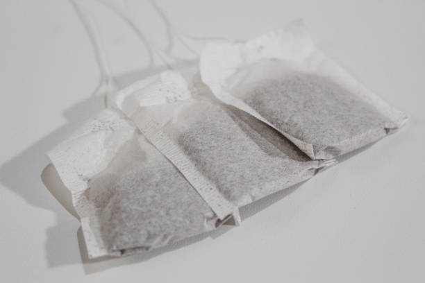 A tea bag with a blank yellow label in a cup. Cozy template with space for text on a tea bag tag.