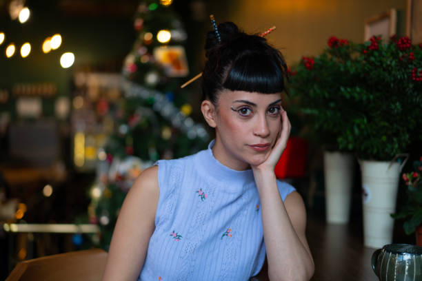 Portrait of a young woman posing with christmas decorations in the background