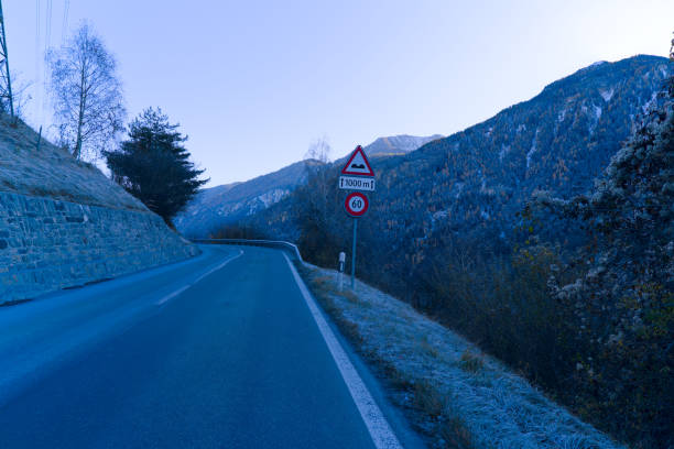 Traffic signs speed limit 60 kilometers per hour and pumps ahead next 1000 meters in the Swiss Alps on an autumn morning. Photo taken November 15th, 2024, Brienz Brinzauls, Switzerland.