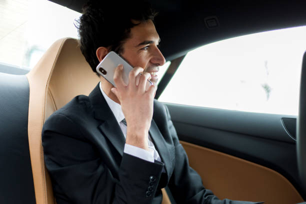 istock Businessman talking on mobile phone while traveling in luxury car 2190907761