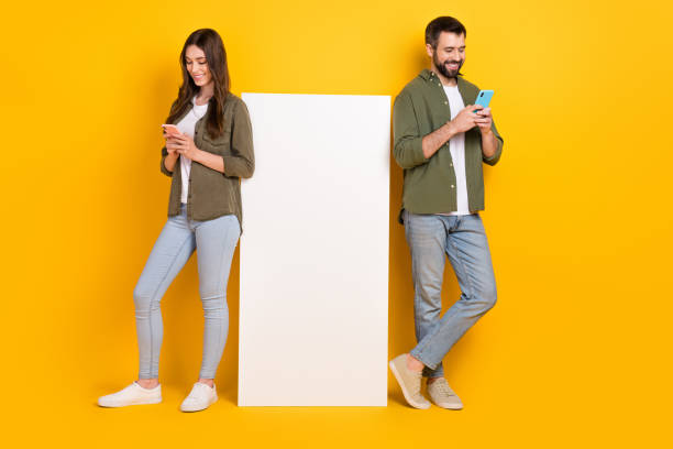 istock Full length body size view of beautiful handsome friends friendship using device copy space isolated over bright yellow color background 2190909491