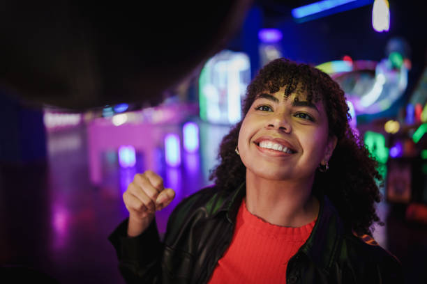 istock Young woman having fun playing punching bag game at amusement park 2190911224