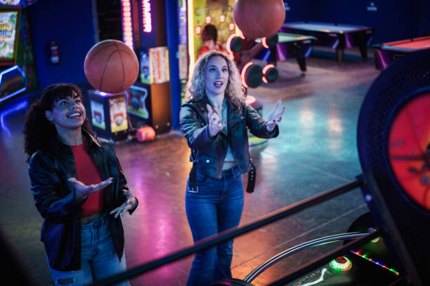istock Two young women playing arcade basketball game 2190911228