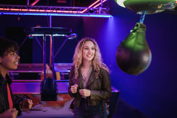 istock Young women playing arcade games in entertainment center 2190911239