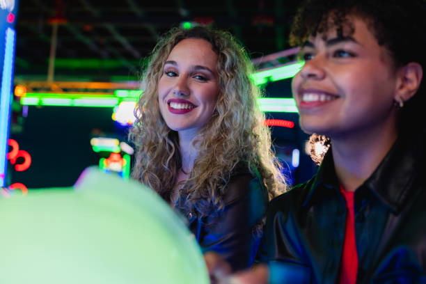 istock Two young women playing arcade games and having fun together 2190911330