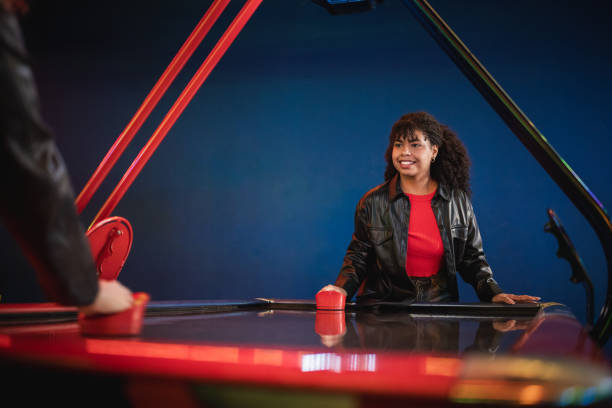 istock Two young adults playing air hockey in an arcade 2190911407