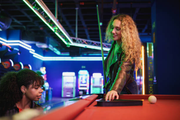 istock Young women playing billiards in amusement arcade 2190911498