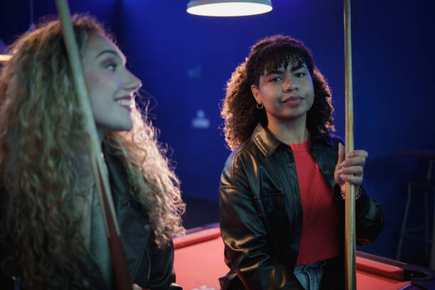 Two friends playing pool in a bar, enjoying their evening together