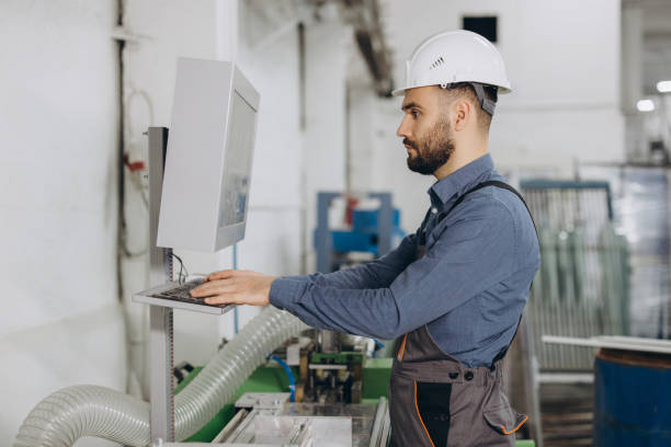 istock Factory worker operating computer controlled machinery for aluminum and pvc windows and doors production 2190911807