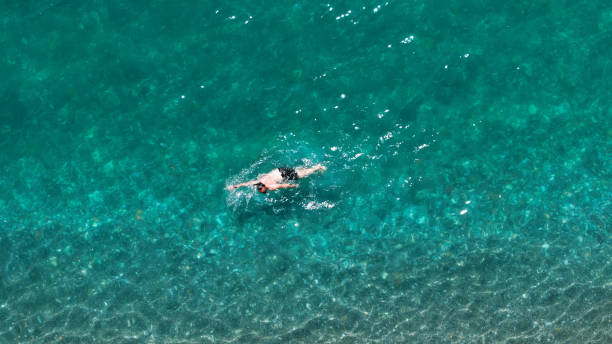 istock Man swimming in crystal clear turquoise water 2190911934