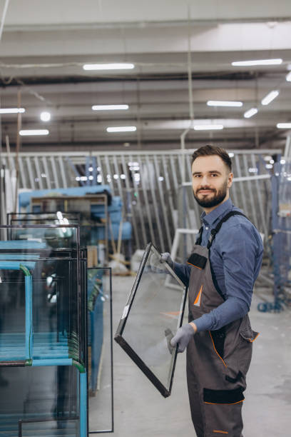 istock Factory worker carrying glass window pane in production line 2190912116