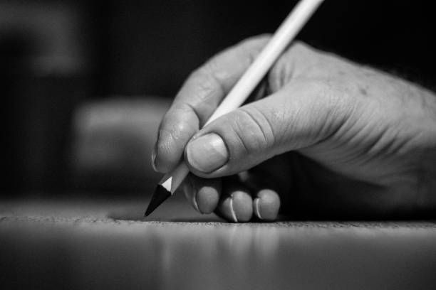 Close-up of a human hand holding a pencil