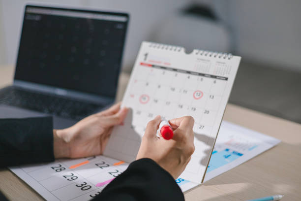 istock Event Planner Schedule Schedule 2025 Plan Event Schedule Businesswoman Checking Planner Taking Notes on Calendar on Office Desk Event Plan Calendar Planning 2190917326