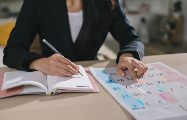 istock Event Planner Schedule Schedule 2025 Plan Event Schedule Businesswoman Checking Planner Taking Notes on Calendar on Office Desk Event Plan Calendar Planning 2190917336