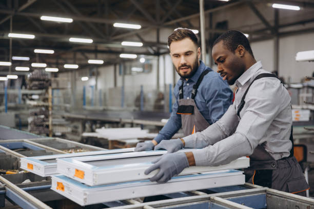 istock Factory workers handling aluminum and pvc window frames on production line 2190917622