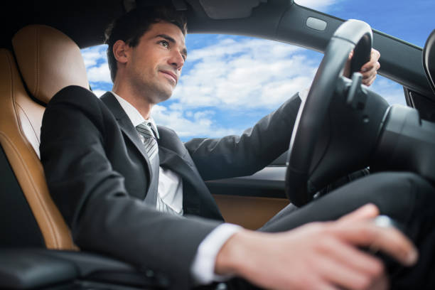 Man beams with happiness as he invites someone to join him in his sleek sedan