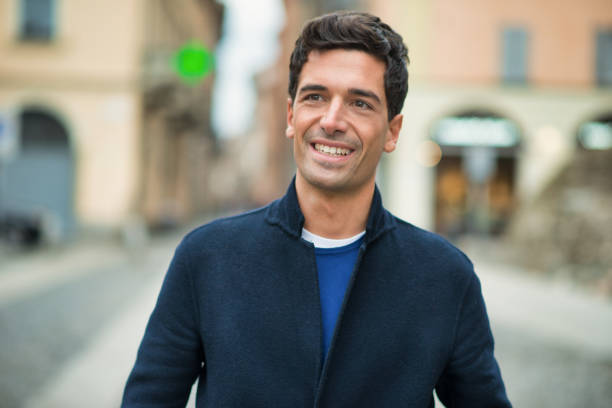 istock Young man smiling and walking in the city 2190917809