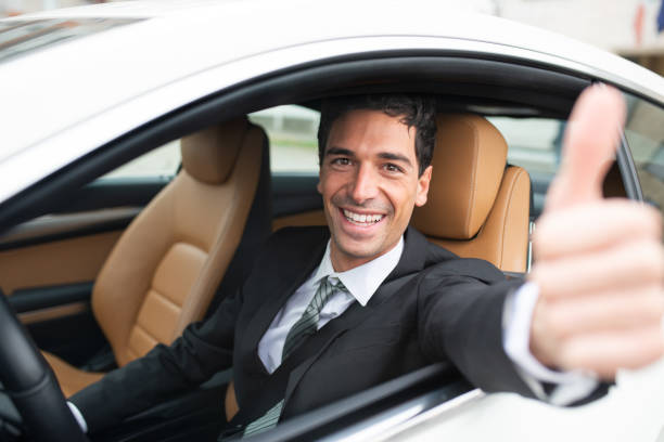 istock Smiling businessman gesturing thumbs up in car 2190918062