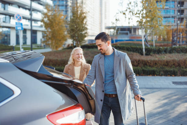 istock Couple loading luggage into car trunk in city 2190918917