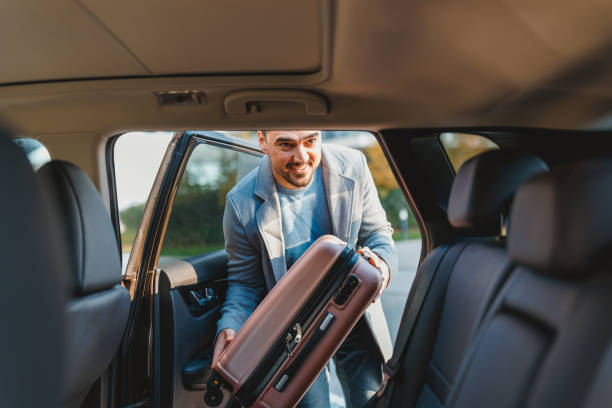 istock Businessman loading luggage into car trunk getting ready for business trip 2190918940