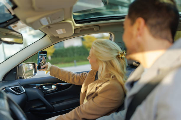 Couple taking selfie while traveling by car