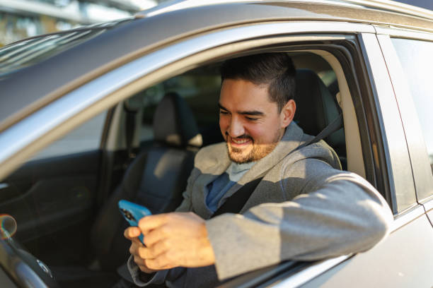istock Young businessman texting on his phone while driving his car 2190919001