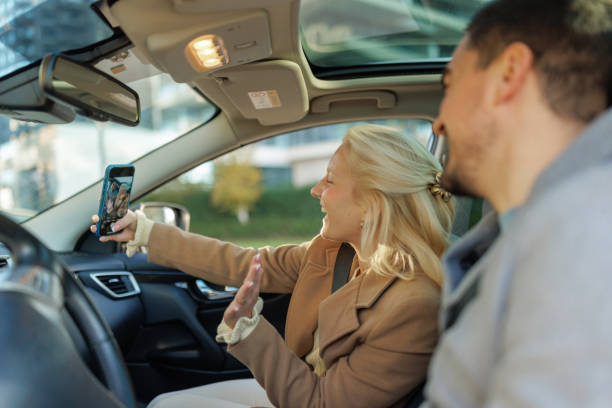 istock Young Couple Video Chatting in Car While Woman is Driving 2190919002