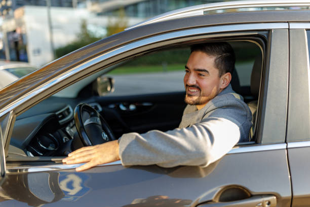 istock Young businessman driving and looking outside the window 2190919014