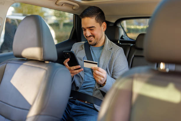 istock Businessman paying for ride-sharing service using credit card and phone in car 2190919074