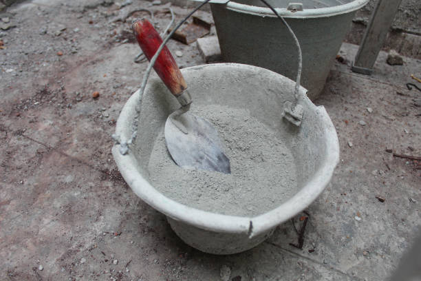 istock Construction bucket, trowel and concrete mix. On a construction site 2190922073