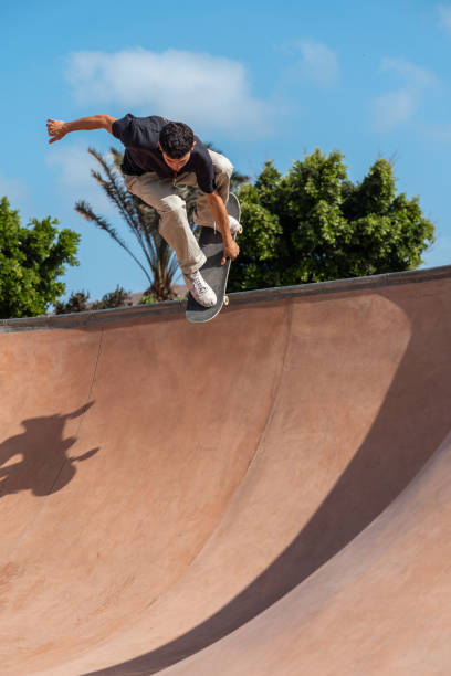 istock young skater wearing black tshirt skating inside a bowl in a skate park. 2190930441