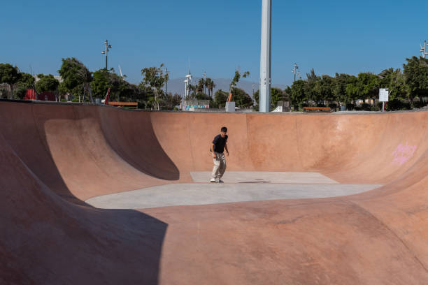 istock young skater wearing black tshirt skating inside a bowl in a skate park. 2190930459