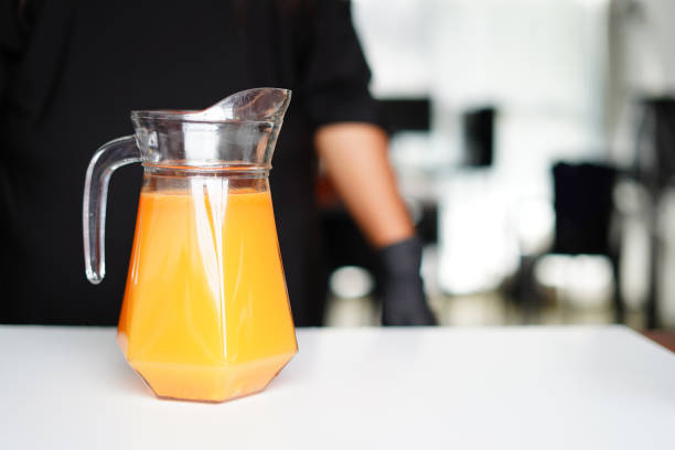 orange juice in a jug on the white table image