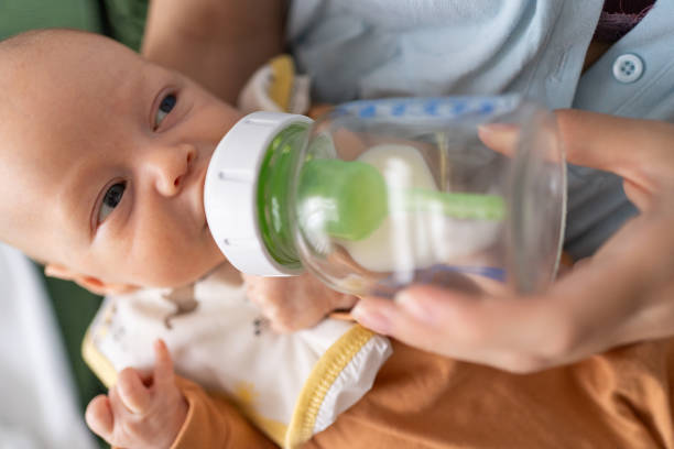 istock Mother feeding newborn with milk from bottle at home 2190932838