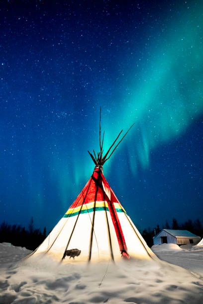 istock Aurora Borealis, northern lights, glow above an illuminated teepee on a freezing cold winter night in the Northwest Territories, Yellowknife,  NWT, Canada 2190934914