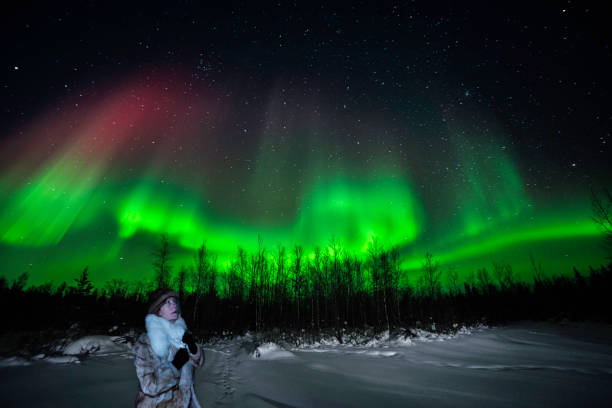 istock Woman watches vivid Aurora Borealis 2190934968