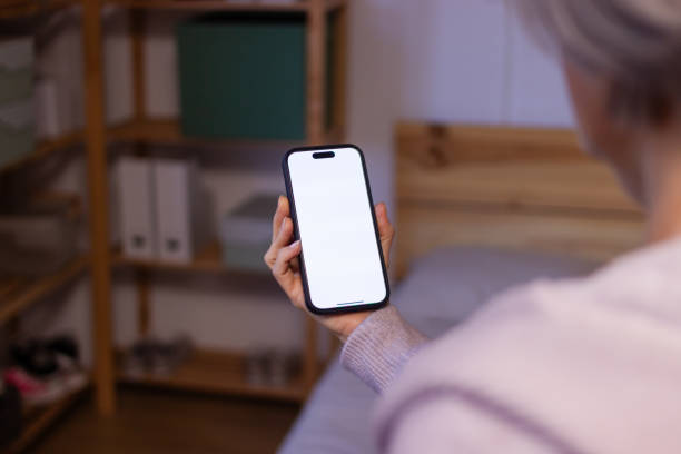 istock Senior woman using smartphone with blank screen at home 2190940155