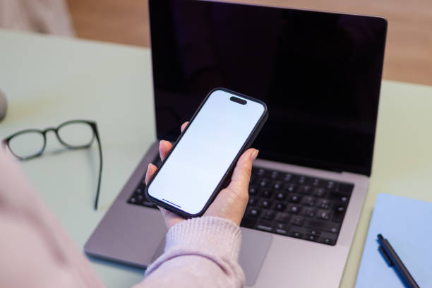 istock Woman holding smartphone with blank screen in home office 2190940193