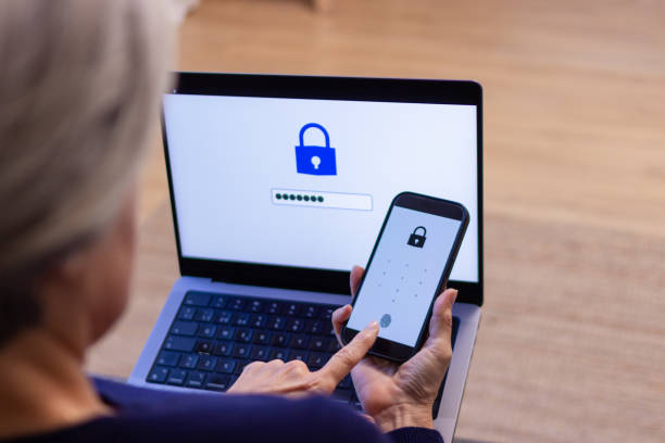 istock Senior woman using two-factor authentication on laptop and smartphone 2190941701