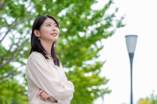 istock A Japanese woman smiling against a tree in the background 2190948599