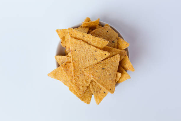 istock Tortilla chips, in triangle shape, on a small white plate. Isolated on white background 2190948902