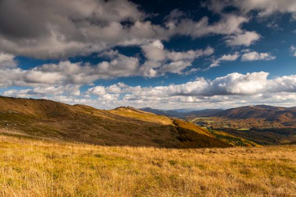 Sunlit Valleys and Shadows in Bieszczady’s FallGolden Hills and Cloudy Skies Over Bieszczady mountains