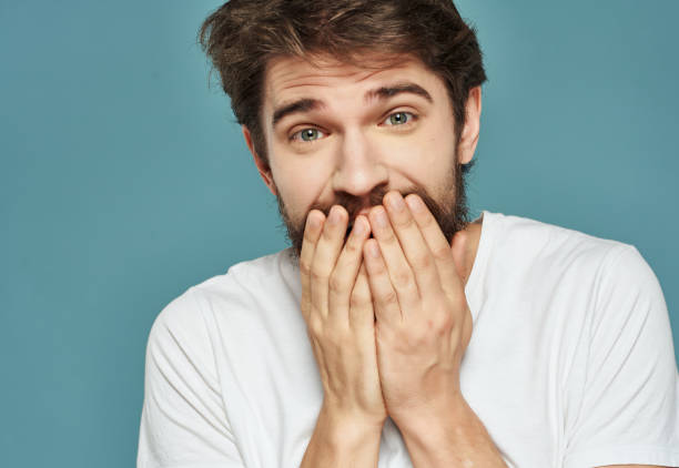 istock Man in a white t-shirt hand gestures anger blue background 2190951220