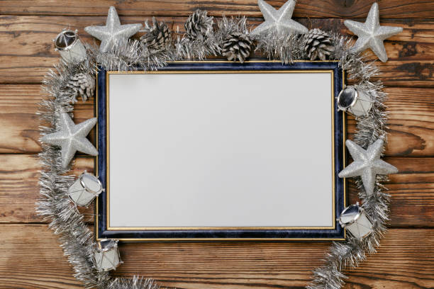 Frame with space for a copy of your images as a keepsake or a greeting text, richly decorated with silver-toned Christmas decorations such as pine cones, stars, drums and garland