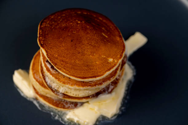 istock thin hot pancakes with butter on a blue plate 2190951731