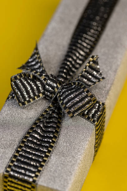 Close up of gift stitch artfully created from golden gift ribbon for decoration on packages and gifts on white background