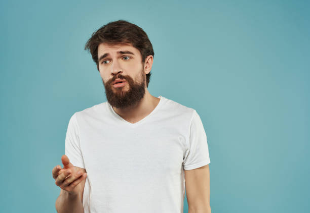 istock emotional man in a white t-shirt serious look Studio 2190952671