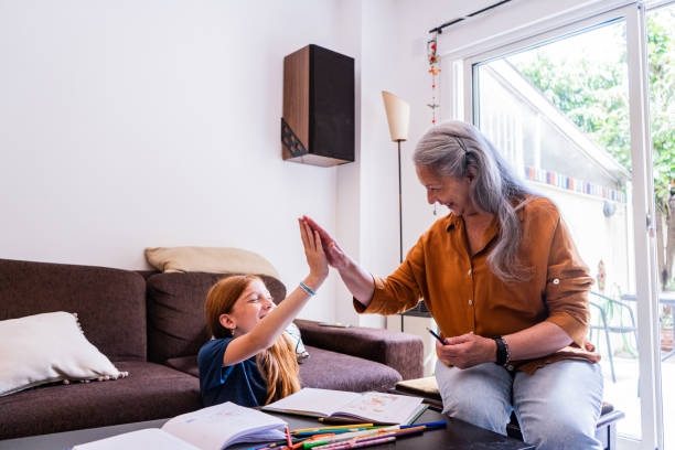 istock Grandmother and granddaughter doing high-five at home 2190953747