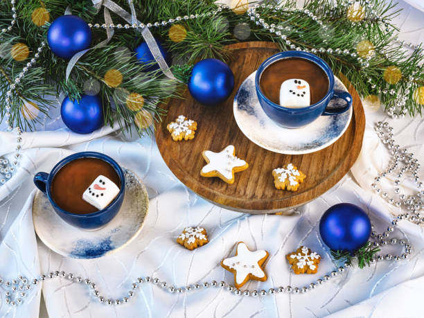 istock Two blue cups of coffee with marshmallows, Christmas gingerbread cookies, Christmas tree decorations, Christmas tree branches 2190961828