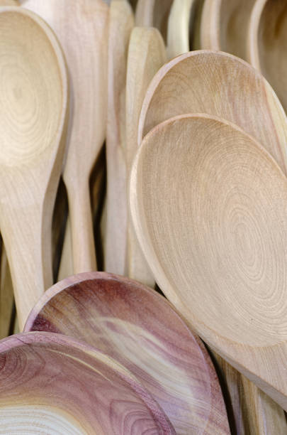 A large group of handmade wooden spoons, abstract domestic background
